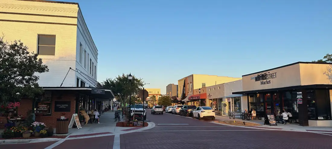 Historic brick storefronts and shops on a downtown Clermont street at sunset